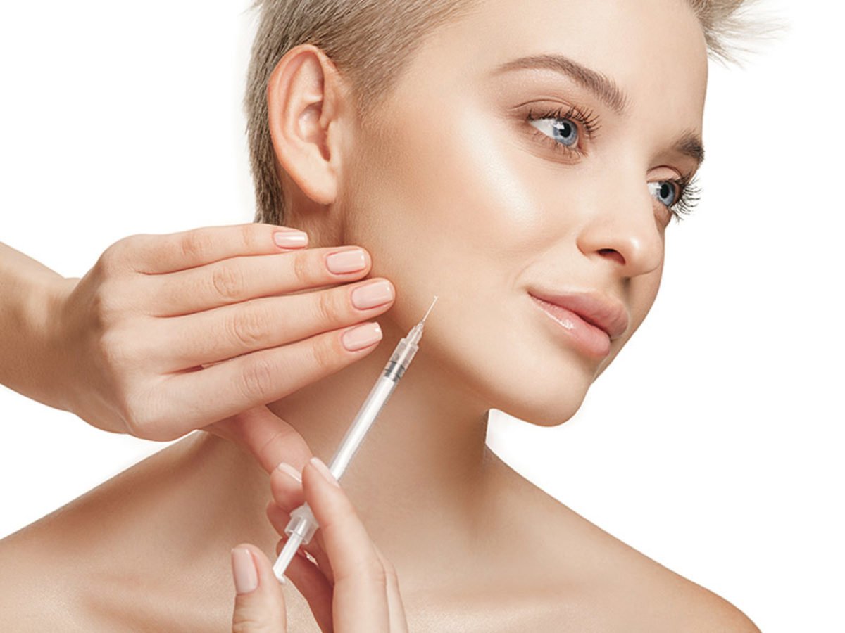 People, Lips, cosmetology, plastic surgery and beauty concept – beautiful young woman face People, Lips, cosmetology, plastic surgery and beauty concept - beautiful young woman face and hand with syringe making injection